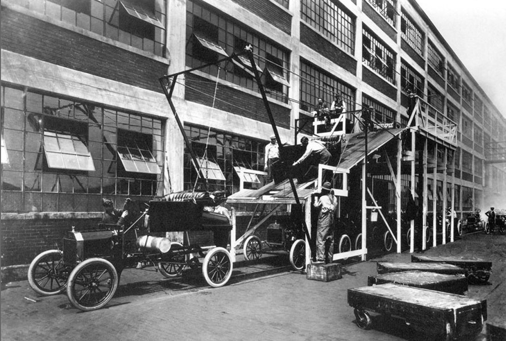 Ford Model T assembly line, 1913, via
			       Wikipedia